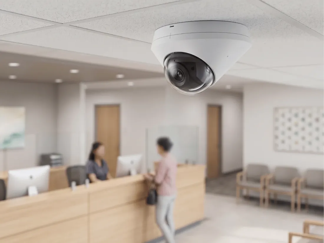 A dome security camera on the ceiling above a reception desk